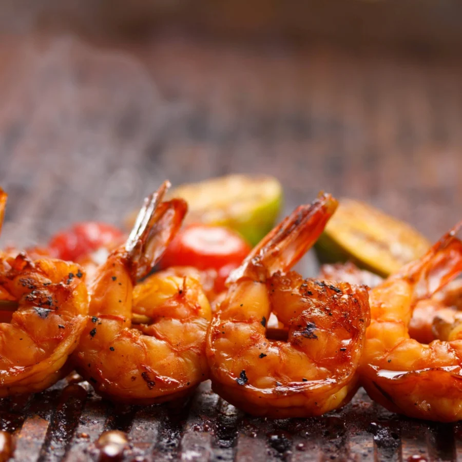 A skewer with four grilled king prawns.