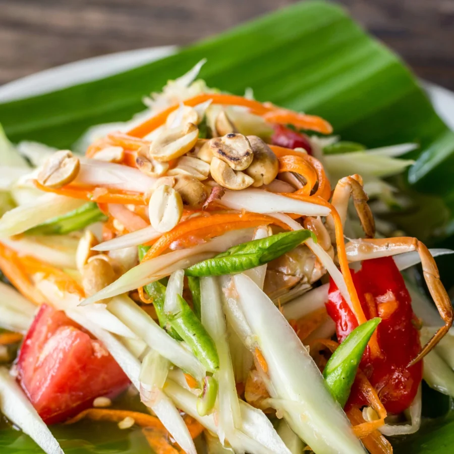 A papaya salad served on a banana leaf.