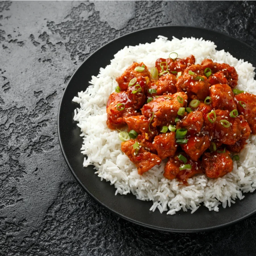 Sweet and sour chicken served on a bed of rice.